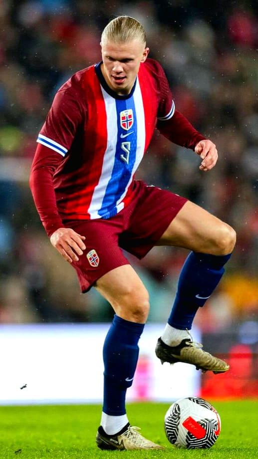 A male soccer player in a red, blue, and white uniform with the number 9 controls a soccer ball on the field during a match, as seen live on Romania IPTV.
