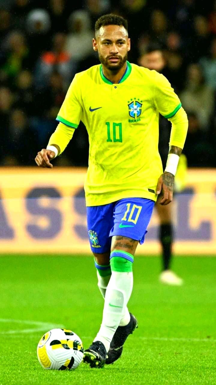 A soccer player in a yellow Brazil jersey with number 10 and blue shorts is on the field, focused and dribbling a ball during a match, which fans can watch live through Romania IPTV.